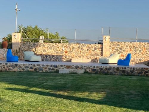 a row of blue chairs sitting on a stone bench at Cindy Luxury Villas Crete GR in Stavros