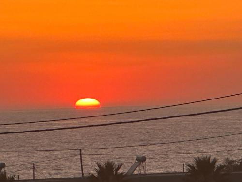 a sunset over the ocean with the sun in the horizon at Cindy Luxury Villas Crete GR in Stavros
