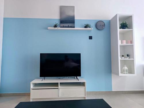 a living room with a flat screen tv on a white entertainment center at Azure Seaview Studio in Priscilla, Caesar Blue Resort, Gym, Heated pool, Sauna, Late check-out in Kalecik