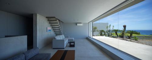 a living room with a view of the ocean at CHLOROBIANCO amami in Amami
