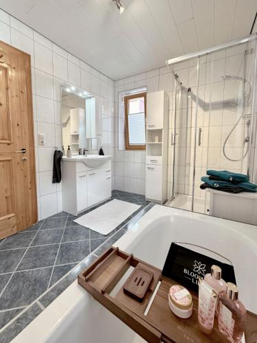 a white bathroom with a tub and a shower at Apartments Jessica Erdgeschoß & Kellergeschoß in Gries im Sellrain