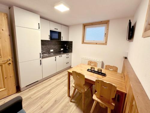 a small kitchen with a wooden table and chairs at Apartments Jessica Erdgeschoß & Kellergeschoß in Gries im Sellrain