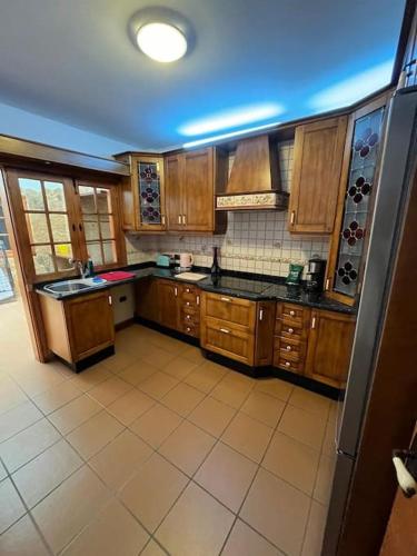 a large kitchen with wooden cabinets and a refrigerator at Centro Toscal 3 dorm Patio Cocina in Los Realejos