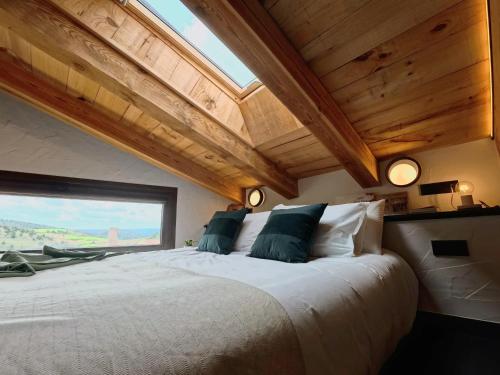a bedroom with a large bed with a large window at Las Horneras de Cobeta Apartamento Petronila in Cobeta