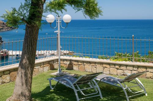 two chairs and a street light next to a tree at Emerald Bay Villa in Balíon