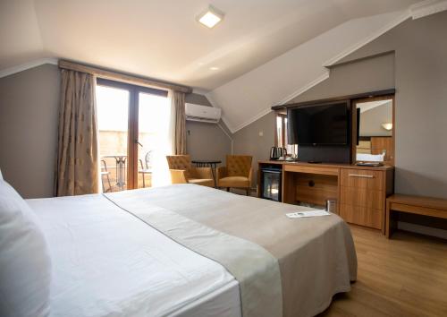 a hotel room with a large bed and a television at New Balturk Hotel Izmit in Kocaeli