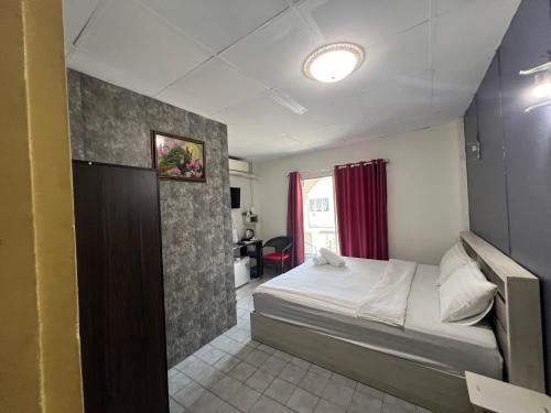 a small bedroom with a bed and a window at DDINN BEACH GUESTHOUSE in Pattaya South