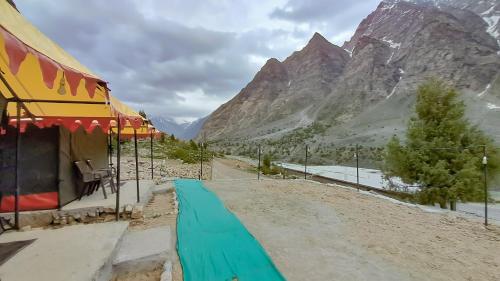 a tent on a dirt road with mountains in the background at Camp Paramount Journeys in Jispa