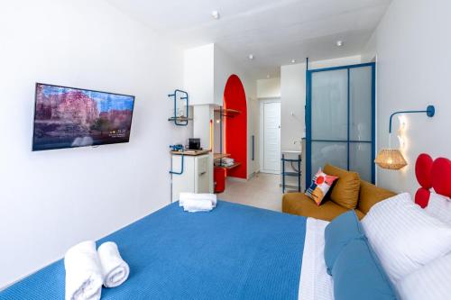 a bedroom with a blue bed and a couch at Patricia Suites in Faliraki