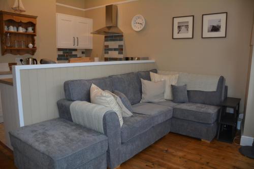 a couch and a chair in a living room at The Fabulous Number Two Apartment a cosy coastal getaway in Cromer
