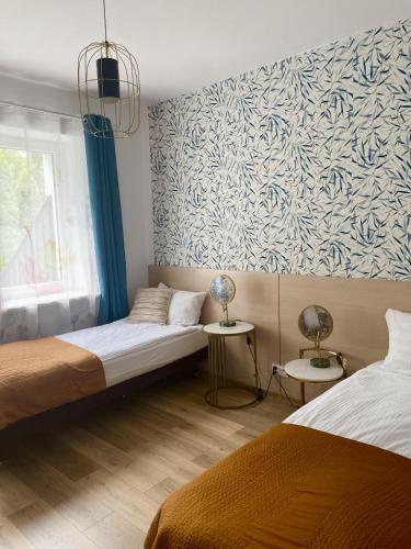 a bedroom with two beds and a wall mural at Villa Lulu in Warsaw