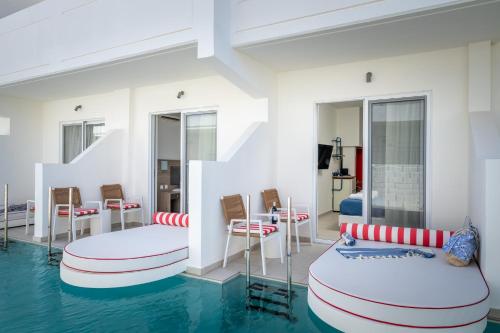 a room with two beds and a pool of water at Patricia Suites in Faliraki