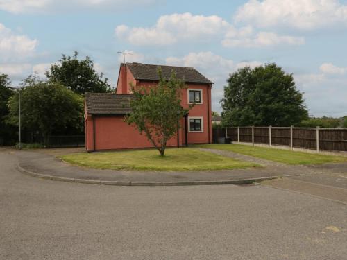 a small red house with a tree in front of it at 1 Eamont Park in Penrith