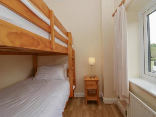 a bedroom with a bunk bed and a window at 1 Eamont Park in Penrith