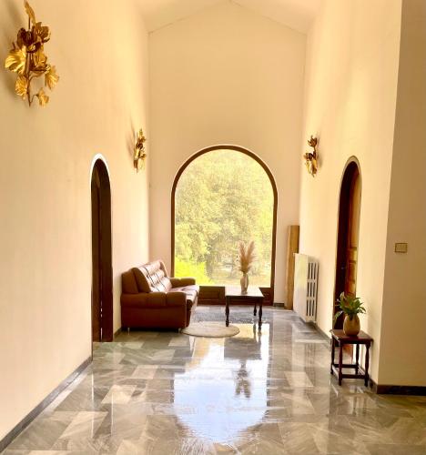 a living room with a couch and a large window at U Palazzu Corte in Corte