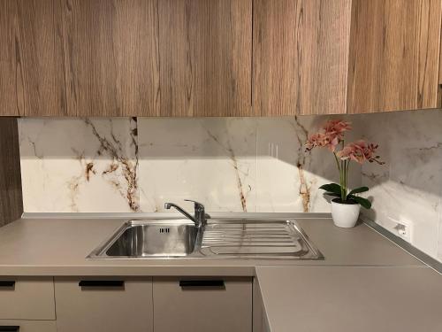 a kitchen counter with a sink and a vase with flowers at Oasis Apartment 1 by GG in Alexandroupoli
