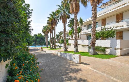 ein Gebäude mit Palmen und einem Pool in der Unterkunft Gorgeous Home In Marina Di Ragusa in Marina di Ragusa