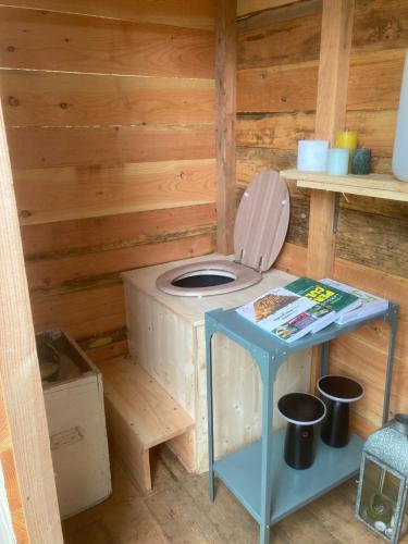 a bathroom with a toilet in a wooden cabin at Le jardin secret in Semur-en-Auxois