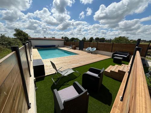 une cour arrière avec une piscine et une terrasse en bois dans l'établissement Noyer, à Étusson