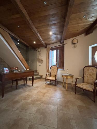 a large room with two chairs and a table and a piano at Il Borgo & il Feudo in Badolato