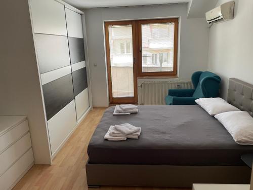a bedroom with a bed and a blue chair at BT Lux apartment 2 in Skopje