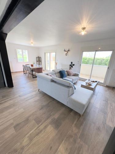 un salon avec un canapé blanc et une table dans l'établissement Villa Safran, à Colombey-les-Deux-Églises