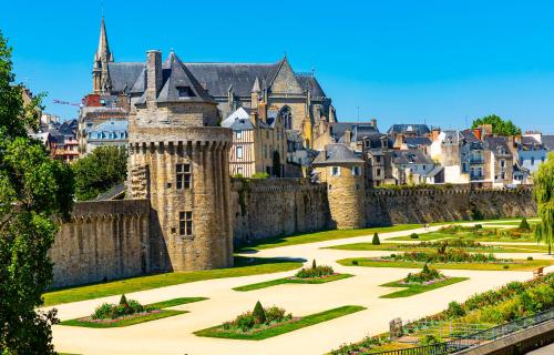 a castle with a garden in front of a city at Charmant studio avec terrasse hyper-centre de Vannes à 5 min du Port et des Remparts in Vannes