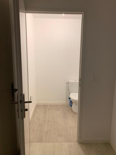une porte ouverte menant à une salle de bains pourvue de toilettes. dans l'établissement Appartement moderne, à Thiais