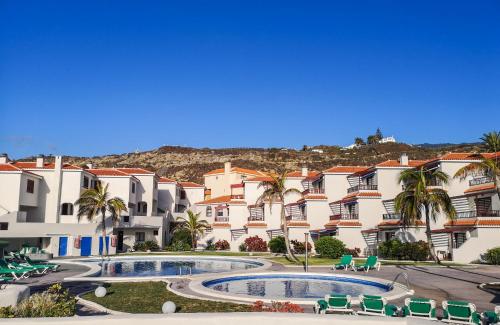 Un grupo de edificios de apartamentos con piscina y palmeras. en Atlantic Dawn, en Los Cancajos