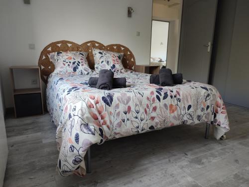 une chambre avec un lit avec un couvre-lit fleuri dans l'établissement Au coeur de l'occitanie, à Cuq
