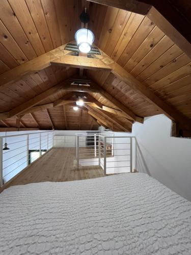 a bedroom with a white bed and a wooden ceiling at Gozzadini Vineyard! in Avlonárion