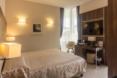 a hotel room with a bed and a television at Hotel Kuma in San Giuseppe