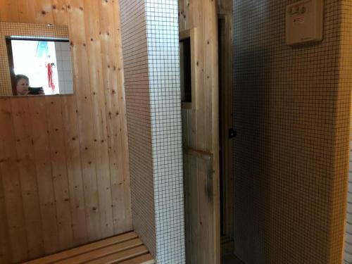 a bathroom with a tiled wall and a person in a mirror at Flims Chalet in Flims