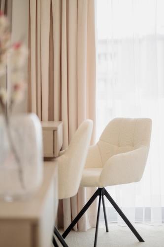 a white chair sitting in front of a window at Aqua Bluemica ADULTS ONLY in Międzyzdroje