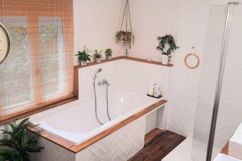 une baignoire dans une salle de bain avec une fenêtre dans l'établissement Maison entre mer et campagne, à Plouha