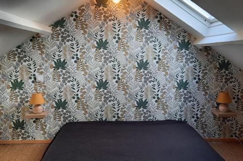 - une chambre avec un lit et un mur à motifs dans l'établissement Maison entre mer et campagne, à Plouha