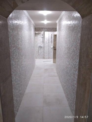 a bathroom with a walk in shower and a tile hallway at Hotel Caesar Palace in Sunny Beach