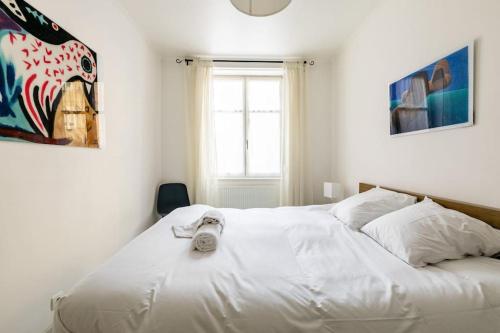 - une chambre avec un lit blanc et une horloge dans l'établissement La Galerie Alsacienne Parking public gratuit, à Strasbourg