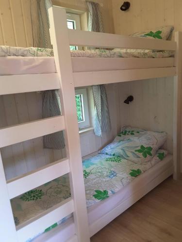 a bedroom with two bunk beds in a room at Morskie Marzenie - domek nr III in Białogóra