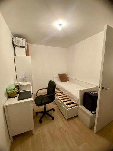 Cette petite chambre comprend un lit, un bureau et une chaise. dans l'établissement Super logement à voir, à Sevran