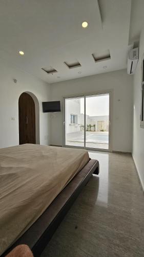 a bedroom with a large bed and a large window at Villa Zain in Houmt Souk