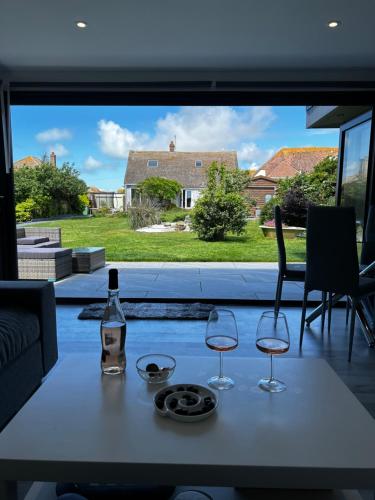 a table with two glasses and a bottle of wine at Whispering Waves Guest house, Brighton-8 mins, Guests 4, Beachfront, Free parking, WiFi, Kitchen and AC in Peacehaven