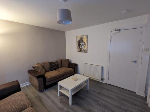 a living room with a couch and a table at 4 bedroom Townhouse Greenock in Greenock