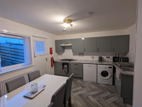 a kitchen with a table and a dining room at 4 bedroom Townhouse Greenock in Greenock