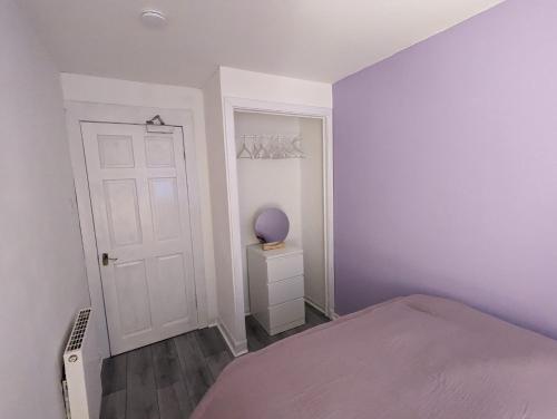 a bedroom with a bed and a white door at 4 bedroom Townhouse Greenock in Greenock