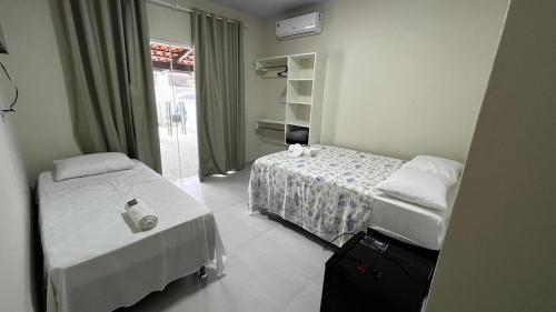 a hotel room with two beds and a window at Pousada D’Uriel in Penha