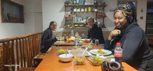a group of people sitting at a table with food at Rainbow Sky Cottage in Ella