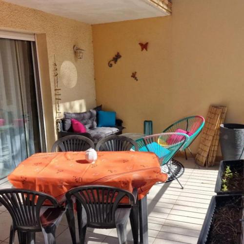 un patio avec une table, des chaises et un canapé dans l'établissement Appartements canet en Roussillon, à Canet