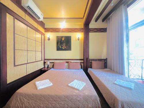 a bedroom with two beds and a window at Bi Saigon Hotel in Ho Chi Minh City