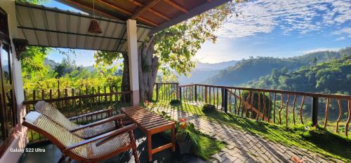 a porch with a bench and a view of the mountains at Rainbow Sky Cottage in Ella